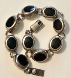 This is a really lovely vintage Mexican 950 (higher silver content than traditional sterling silver) bracelet dating to the 1960s-70s. The bracelet has a box slide clasp and is comprised of 9 oval silver and onyx links, each incredibly well constructed and attached to one another. It's signed on the clasp: MEX 950 HOB, which I have come to learn means it was made by a company called HOUSE OF BANGLES. On the larger side, this would be best for a medium to large woman's wrist. I have a medium/smal Style 2025, Retro Gadgets, Black Onyx Bracelet, Onyx Bracelet, Vintage Mexican, Cuff Bangles, Dream Jewelry, Earrings Photo, Sterling Silver Bracelet