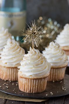 cupcakes with white frosting and a sparkler on top