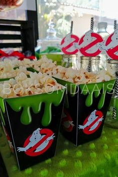 popcorn buckets filled with halloween treats on a table