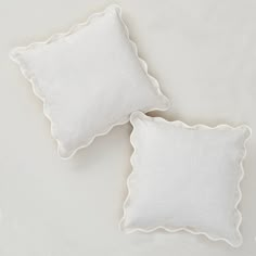 two white pillows with scalloped edges