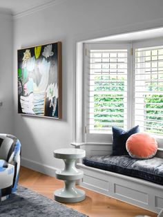 a living room filled with furniture and windows covered in shuttered glass shades on top of them