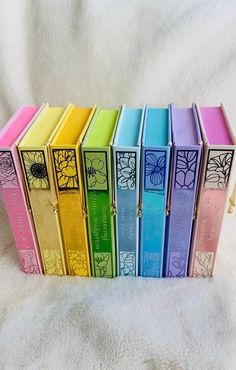 a row of colorful books sitting on top of a white blanket