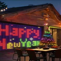 a christmas tree is lit up in front of a building with many lights on it