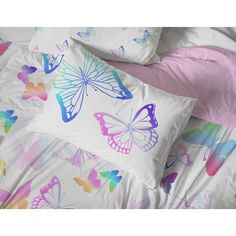 a bed with butterflies on it and pink sheets in the foreground, along with two pillow cases