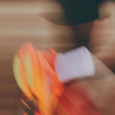 blurry photograph of a person riding a bike on the street with an orange and yellow blanket