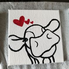 a white towel with a black and red drawing of a cow on it's side