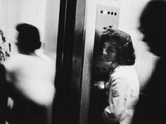 black and white photograph of people entering an elevator