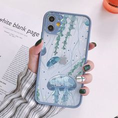 a woman holding up her phone case with jellyfishs and plants on the back