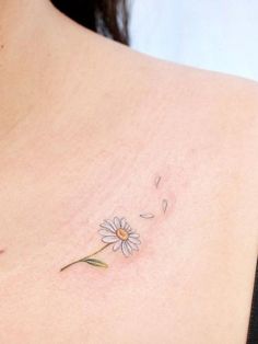 a woman with a tattoo on her back has a flower in the middle of her chest