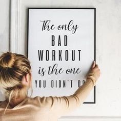 a woman is holding up a poster that says the only bad workout is the one you didn't do