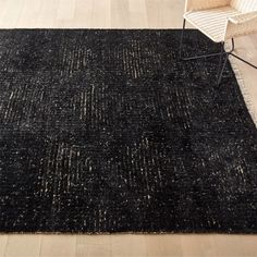 a black area rug with white lines on the floor and a chair next to it