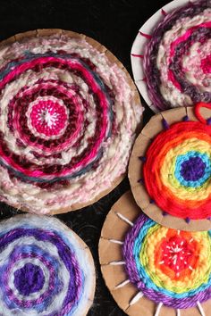 three colorful crocheted coasters sitting next to each other on a black surface