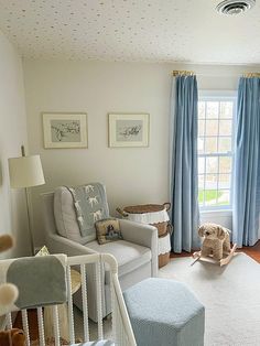 a baby's room with blue drapes and white walls, including a crib