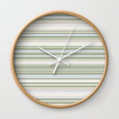 a clock that is on the wall with stripes in green and grey colors, showing time