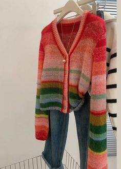 a colorful cardigan sweater hanging on a clothes rack