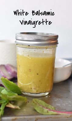 a jar filled with white balsamic vinaigrete sitting on top of a table