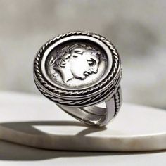 Adorn your style with the unique Alexander the Great Portrait Coin Ring. Crafted from high-quality sterling silver, this handmade Greek jewelry piece brings the timeless legacy of Alexander the Great to life with its portrait design. A great statement piece for any wardrobe. The entire ring is made of sterling silver.  Sterling Silver Ring the brightest of all precious metals Handcrafted Ring. Forget the standardized jewelry on the market! Stand out with our individually ELEFTHERIOU EL handcraft Macedonian Empire, Greek Ring, Handmade Sterling Silver Rings, Antique Coins, Greek Jewelry, Portrait Design, Coin Ring, Unisex Necklace, Alexander The Great