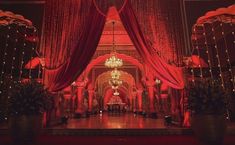 a stage set up with red drapes and chandeliers