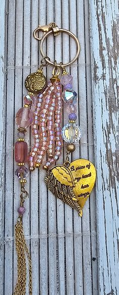 a close up of a key chain on a wooden surface with beads and charms hanging from it