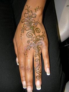 a woman's hand with henna tattoos on it