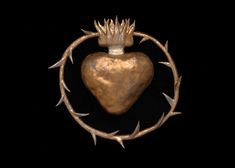 a heart with crown on it surrounded by thorns and barbed wire against a black background