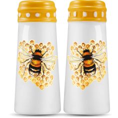 two yellow and white ceramic jars with bees on the front, one is filled with honey