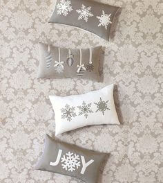 four decorative pillows with snowflakes on them