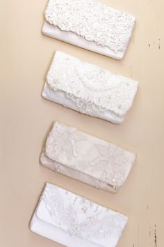 four white clutches are lined up on a table