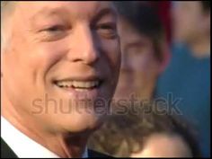 an older man in a tuxedo smiles at the camera with his eyes closed