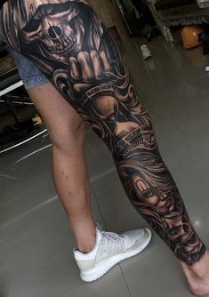 a man's leg with a tattoo on it and a skull in the middle