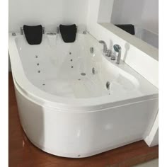 a white bath tub sitting on top of a wooden floor