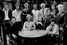 a group of people posing for a photo in front of a round table with chairs