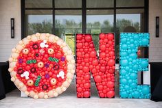 there is a large letter made out of balloons and a pizza in the shape of letters