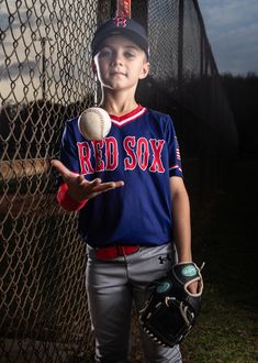 a young boy holding a baseball and glove