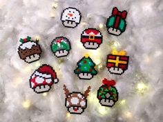 six pixelated christmas ornaments are arranged on a white furnishing with lights in the background