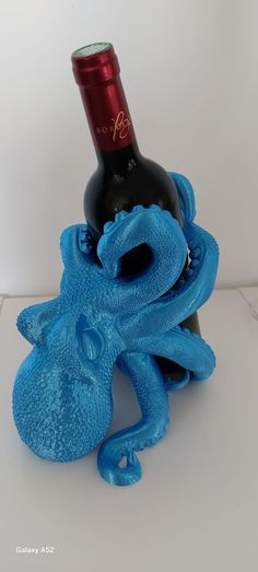 a blue octopus bottle holder with a red wine bottle