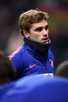 a close up of a soccer player wearing a blue jacket and black neck gaiter