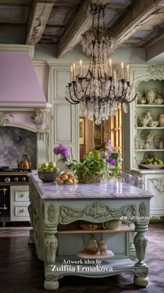 a kitchen with an island and chandelier hanging from the ceiling in front of it