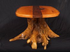 a table made out of wood with two legs and a wooden top that has been carved to look like a tree stump