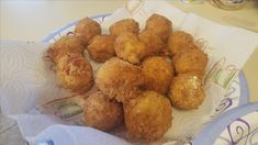 some fried food sitting on top of a white paper towel next to a blue and white plate