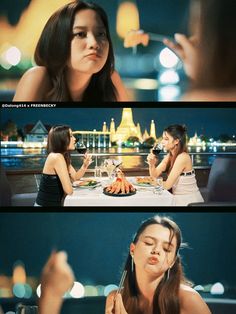 two women sitting at a table with food in front of them and one woman eating