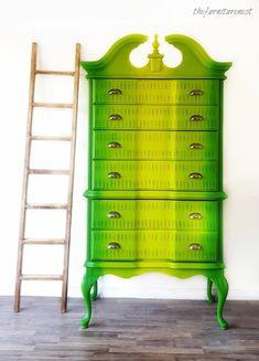 a green dresser sitting next to a ladder