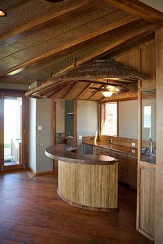 a kitchen with wood floors and an island in the middle, surrounded by wooden walls