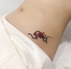 a woman's stomach with a rose tattoo on it