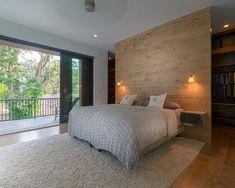 a large bed sitting in the middle of a bedroom next to a sliding glass door