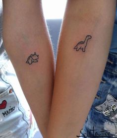 two people with matching tattoos on their arms, one has a cat and the other has a dog