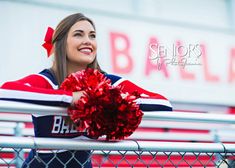 a cheerleader holding a pom - pom in front of the bleachers