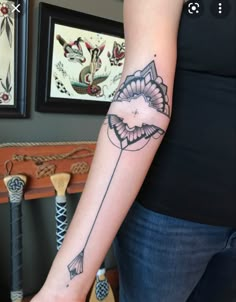 a woman's arm with an arrow tattoo on it