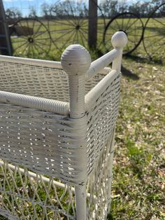 a white wicker bed frame in the grass