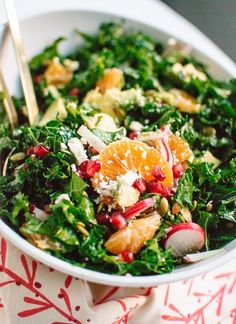 a white bowl filled with salad and oranges